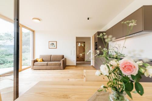 a living room with a couch and a vase of flowers at Firmelein in Appiano sulla Strada del Vino