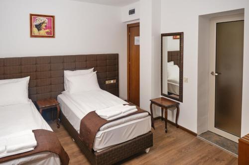 a hotel room with two beds and a mirror at Hotel Splendid in Pleven