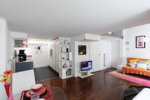 a living room with a couch and a television at My London Holiday Home in Woolwich