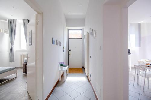 a hallway with white walls and a white floor at Downtown Rooms in Como