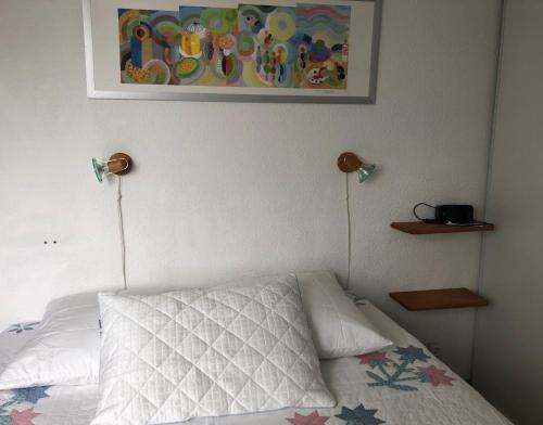 1 dormitorio con 1 cama con 2 luces en la pared en Moulis, en Hourtin