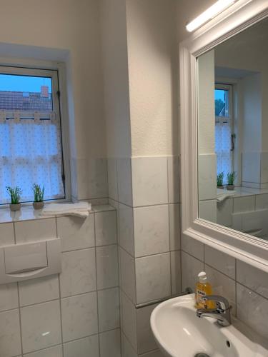 a white bathroom with a sink and a mirror at Ferienhaus SüdWest in Bosau