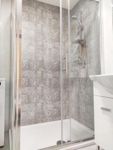 a shower with a glass door in a bathroom at White Studio Apartman in Pula