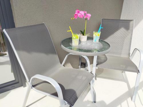 ein Tisch mit einem Stuhl und zwei Getränken darauf in der Unterkunft White Studio Apartman in Pula