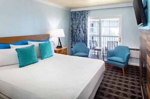 a bedroom with a bed and two blue chairs at Beach Retreat & Lodge at Tahoe in South Lake Tahoe