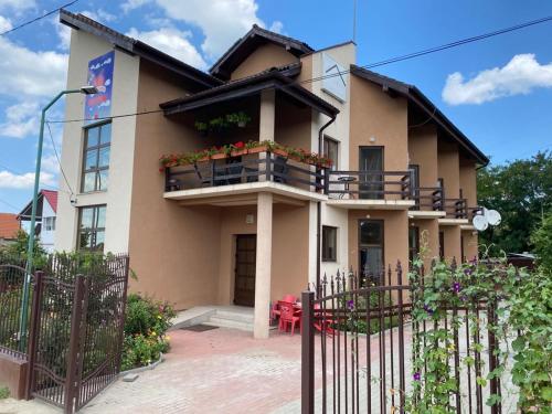 une maison avec un balcon fleuri dans l'établissement Pensiunea Casa Soarelui, à Şimian
