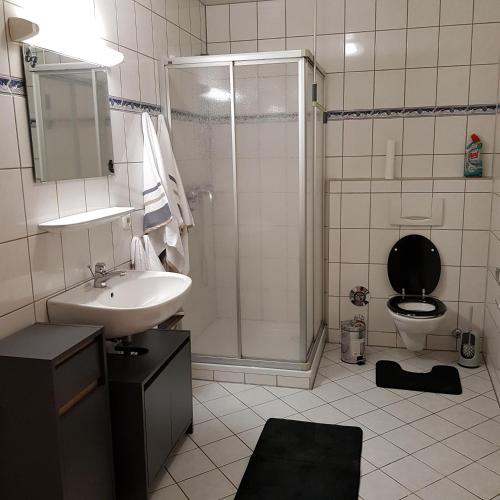 a bathroom with a sink and a shower and a toilet at Gasthaus Kristall in Salzwedel