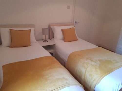 ロンドンにあるBeautiful home in Londonのベッド2台が隣同士に設置された部屋です。