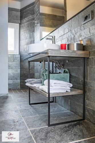 a bathroom with a sink on a shelf with towels at Capriccio Art Hotel in Serravalle Scrivia