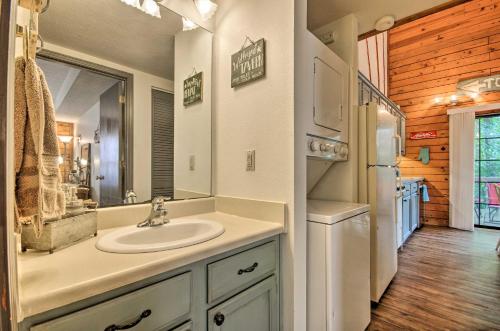 a bathroom with a sink and a mirror at Charming Branson Getaway with Fireplace and Porch in Branson