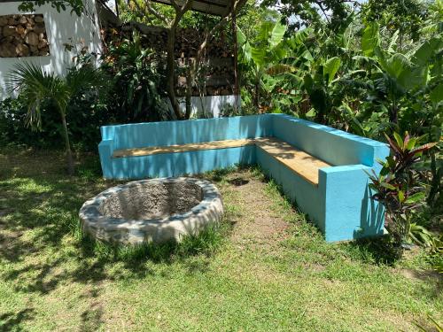 a blue bench sitting in the grass in a yard at Haus unter Palmen in Jarabacoa