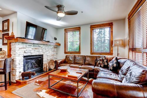 a living room with a leather couch and a fireplace at BlueSky Breckenridge in Breckenridge