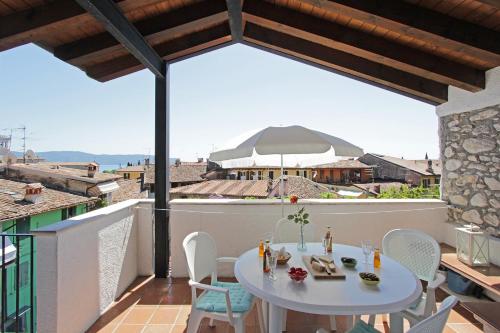 d'une table et de chaises blanches sur un balcon. dans l'établissement Casa Marsilva - holiday apartment with roof terrace, near the lake, à Toscolano Maderno