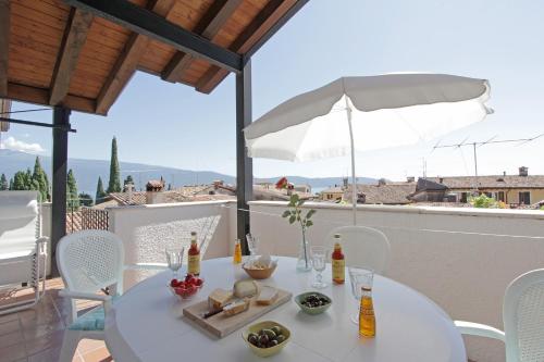- une table blanche avec de la nourriture et des boissons sur un balcon dans l'établissement Casa Marsilva - holiday apartment with roof terrace, near the lake, à Toscolano Maderno