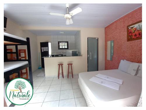 Pousada Naturale في ترينيداد: غرفة نوم بسرير ومطبخ مع كونتر