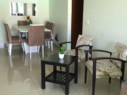 a dining room with a table and chairs and a table and a tableablish at Apartamento frente ao mar in Saquarema