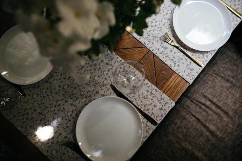 a table with white plates and silverware on it at Don Major in Rostov on Don