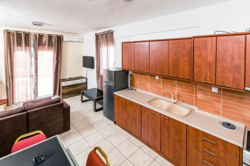 a kitchen with wooden cabinets and a couch in a room at Halkidiki Greek Pride Villa Ellada in Fourka