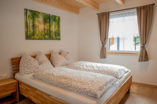 a bedroom with a bed and a window at BergAufe Chalets Mallnitz in Mallnitz