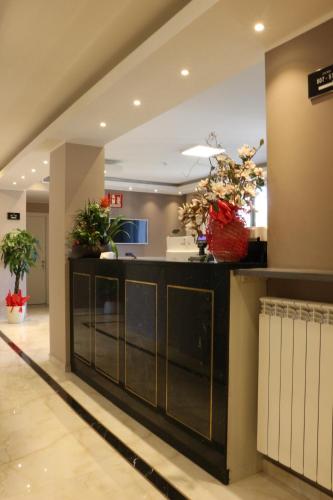 a lobby with a counter with plants on it at Hotel Folen in Milan