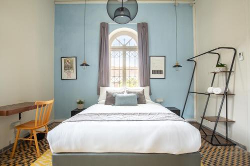 a bedroom with a large bed and a window at Selina Neve Tzedek Tel Aviv in Tel Aviv
