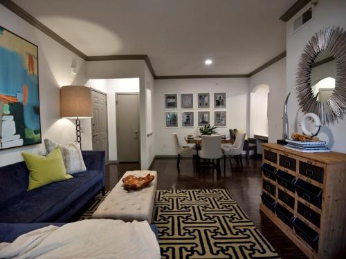 a living room with a blue couch and a dining room at Lavish Apartment near Houston Medical Centre in Houston