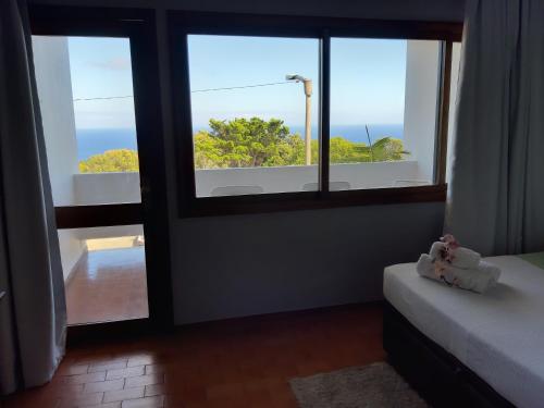 a bedroom with a window with a view of the ocean at Apartamentos Matur in Machico