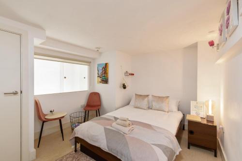 a bedroom with a bed and a chair and a window at My London Holiday Home in Woolwich