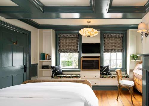 a bedroom with a white bed and two windows at Life House, Nantucket in Nantucket