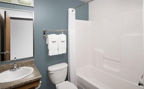 a bathroom with a white toilet and a sink at WoodSpring Suites Allentown Bethlehem in Bethlehem