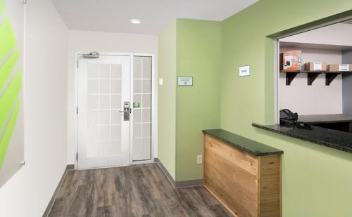 a bathroom with green and white walls and a mirror at WoodSpring Suites Allentown Bethlehem in Bethlehem