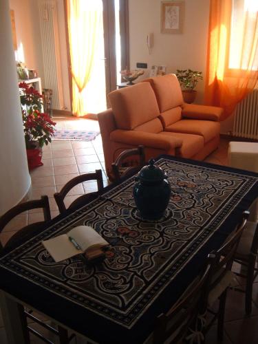 a table with a book and a vase on top of it at B&B Il Guado in Voghenza
