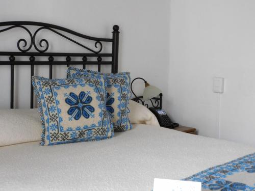 a bed with a blue and white pillow and a lamp at Quinta Alhóndiga Galindo Hotel Boutique in Cholula
