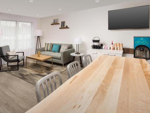 a living room with a large wooden table and a couch at WoodSpring Suites Seattle Tukwila in Tukwila
