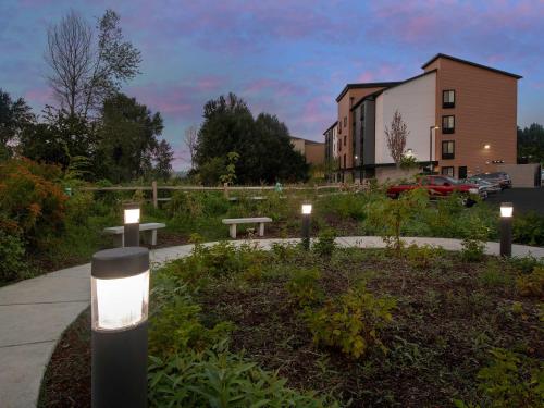 a park with benches and lights in front of a building at WoodSpring Suites Seattle Tukwila in Tukwila