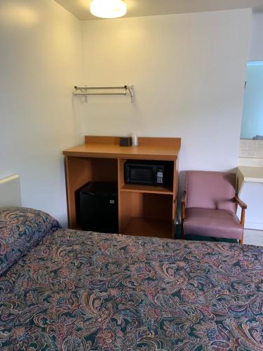 a hotel room with a bed and a desk and a chair at Boone trail inn in Middlesboro