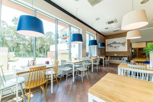 a restaurant with tables and chairs and blue lights at Best Western Hotel Jurata in Jurata