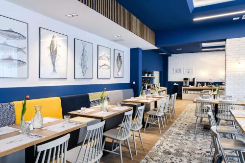 a dining room with tables and chairs and blue walls at Best Western Hotel Jurata in Jurata