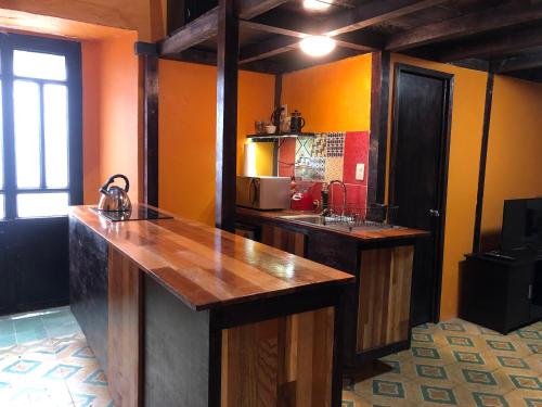 a kitchen with a counter with a sink and a microwave at La Esmeralda Oaxaca in Oaxaca City
