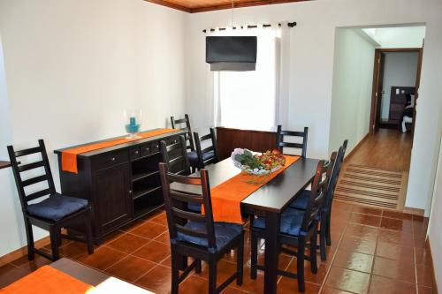 a kitchen and dining room with a table and chairs at Casa da Abrótea in Lajes do Pico