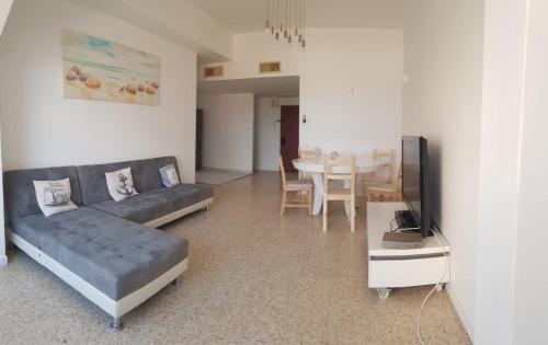 a living room with a couch and a table with a television at Shantell Boutique Apartments in Netanya