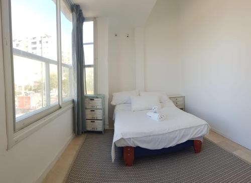 a small bedroom with a bed and a window at Shantell Boutique Apartments in Netanya