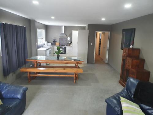 a living room with a table and a kitchen at Koromatua Homestead in Whatawhata