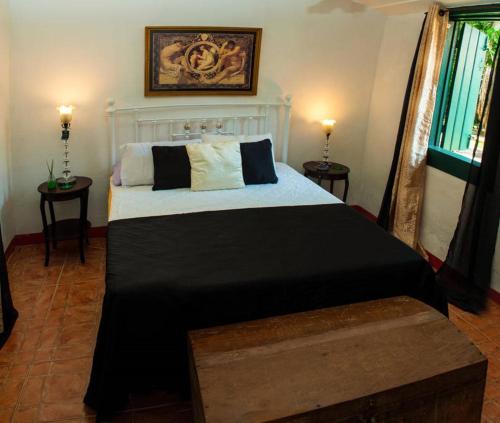 1 dormitorio con 1 cama grande con sábanas blancas y negras en Casa Colonial em Praia Paradisíaca, en Barra de São João