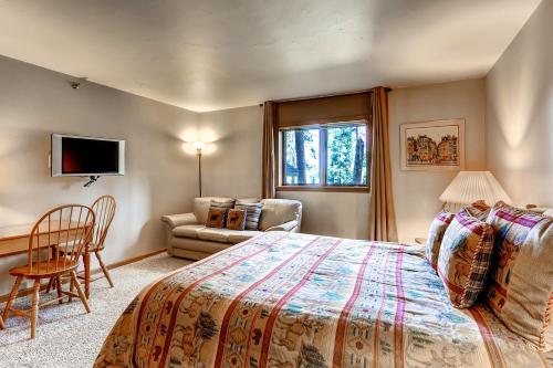 1 dormitorio con 1 cama, 1 silla y 1 sofá en Atrium Condo #002, en Breckenridge