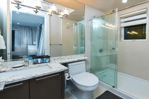a bathroom with a toilet and a glass shower at The Chateau in Burnaby