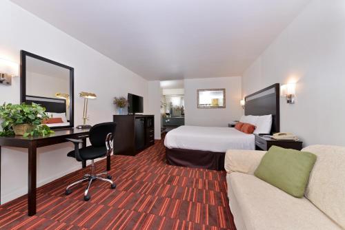 a hotel room with a bed and a desk at Windemere Hotel & Conference Center in Mesa