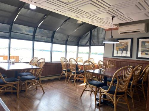 a dining room with tables and chairs and windows at Travelodge by Wyndham Miramichi New Brunswick in Miramichi