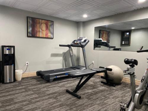 a room with a gym with a treadmill and a mirror at Travelodge by Wyndham Miramichi New Brunswick in Miramichi