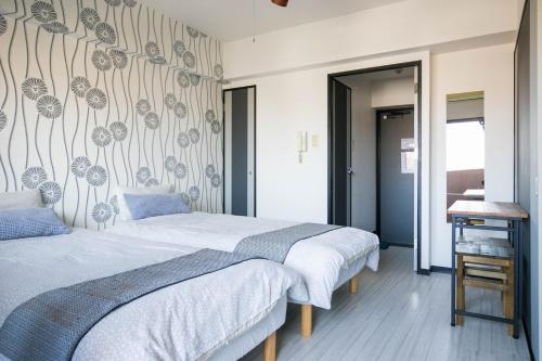 a bedroom with two beds and a wall mural at SUMIYOSHI APARTMENT Hotel 住吉アパートメントホテル in Fukuoka